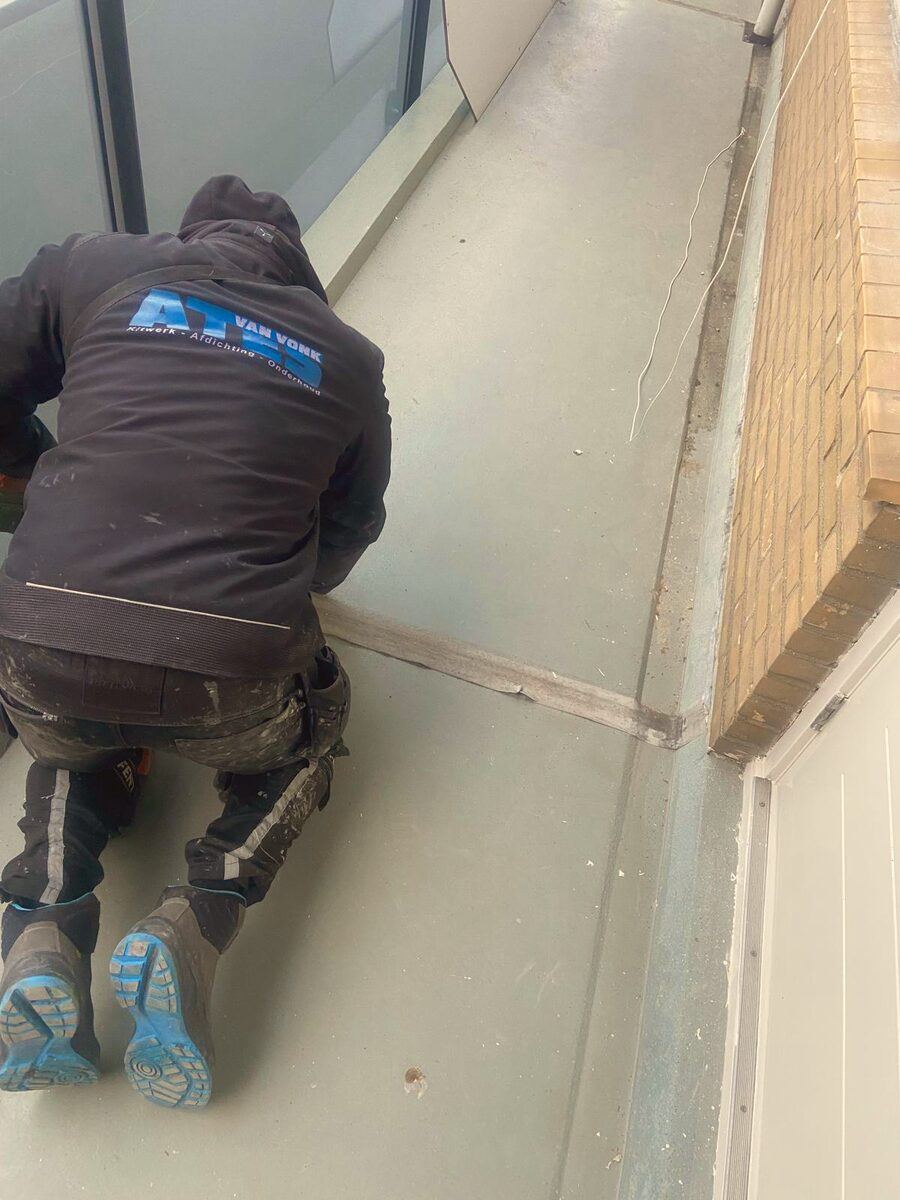 Vakman tijdens kitwerk op de bouwplaats